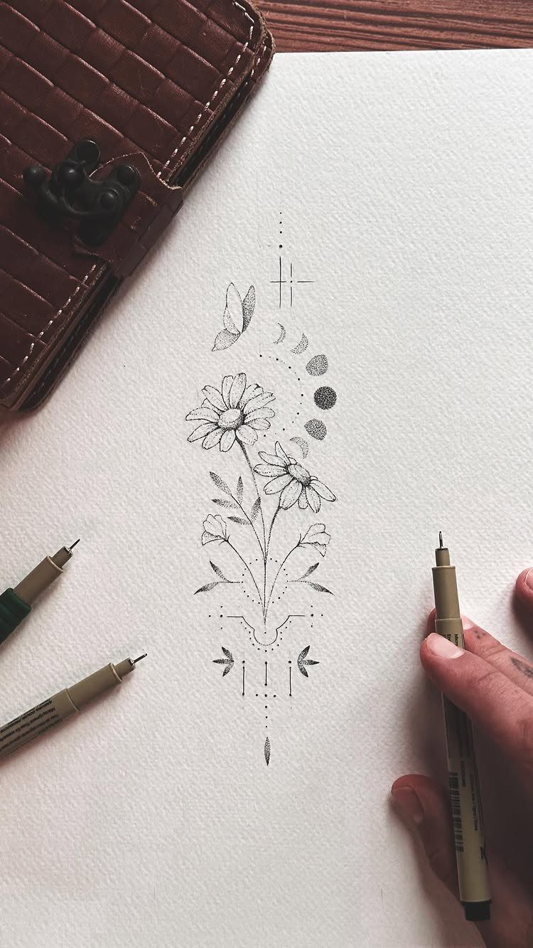 Daisy flower tattoo design sketch with celestial elements on white textured paper
