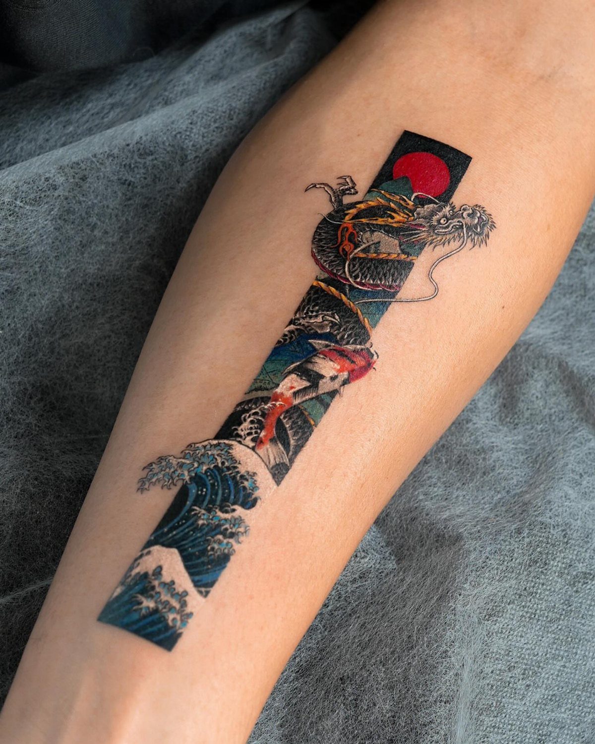 Tattoo of a black dragon and red koi fish with ocean waves.