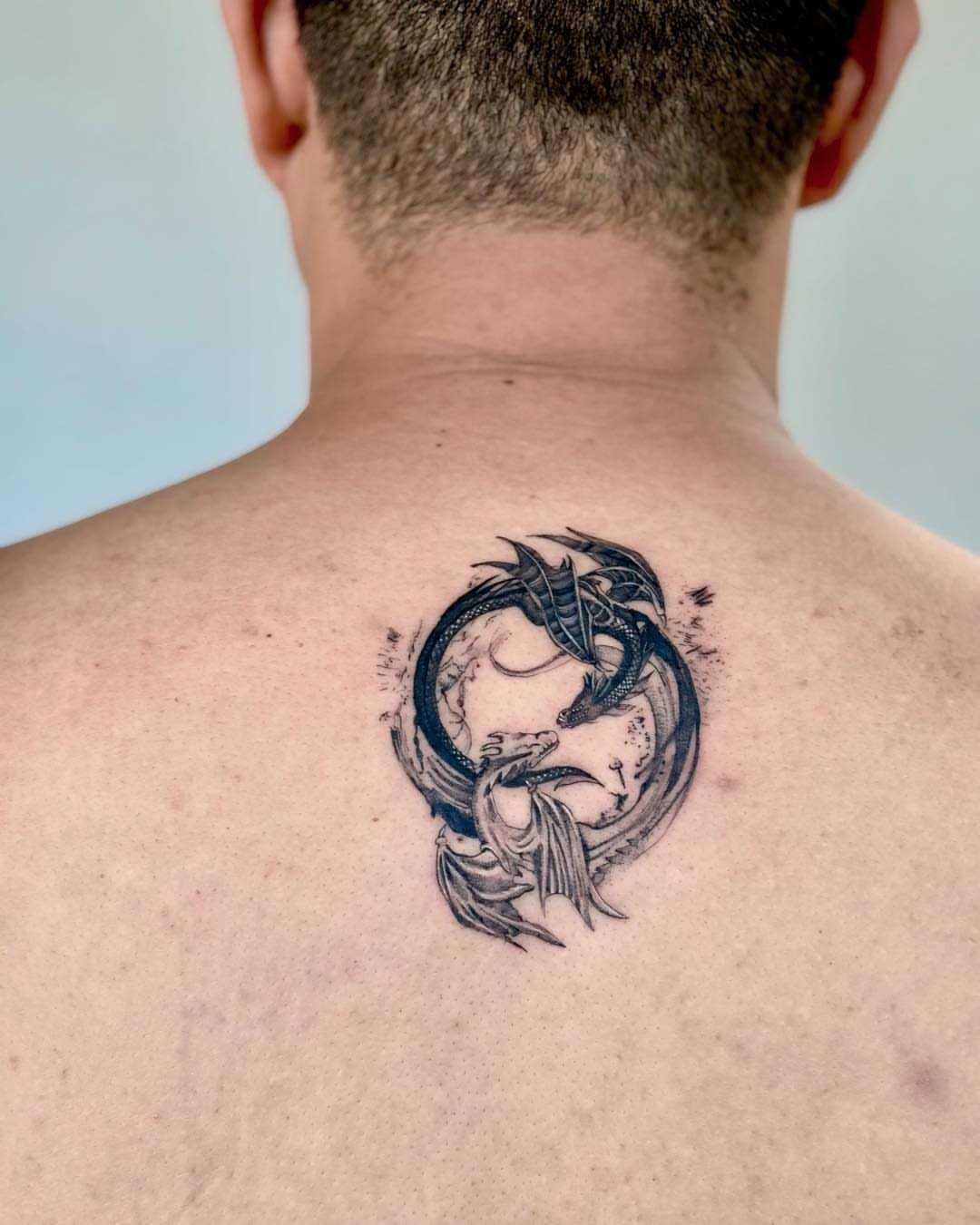 Yin yang dragon tattoo on the upper back of a man
