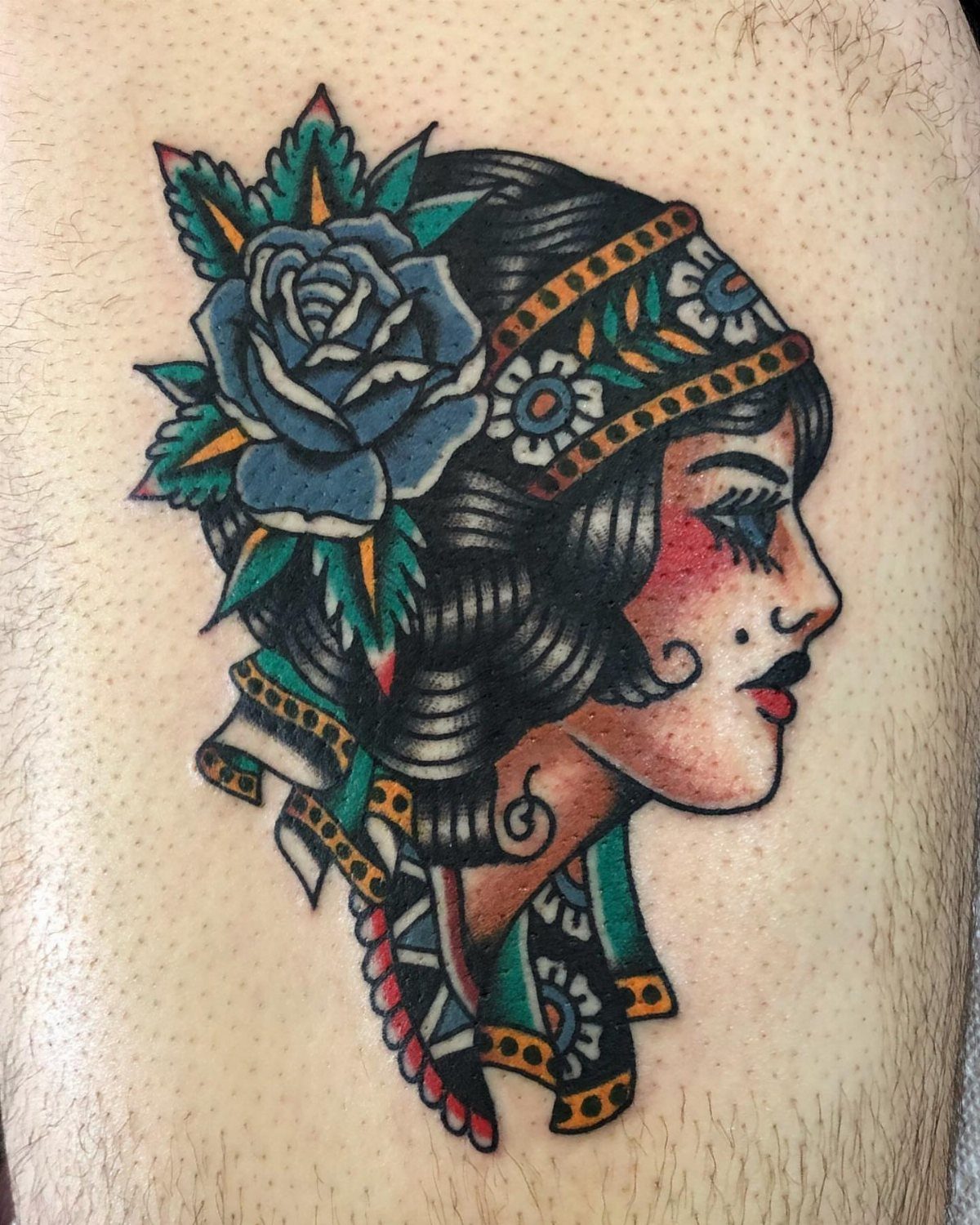Tattoo of a woman's profile with a large blue rose in her hair