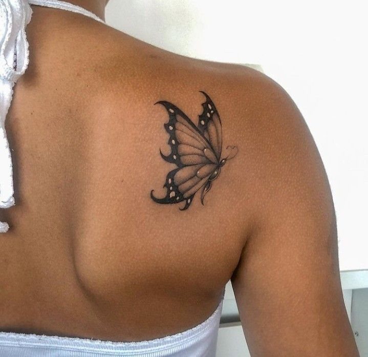 Butterfly tattoo on a shoulder with detailed wing veins and black ink shading.