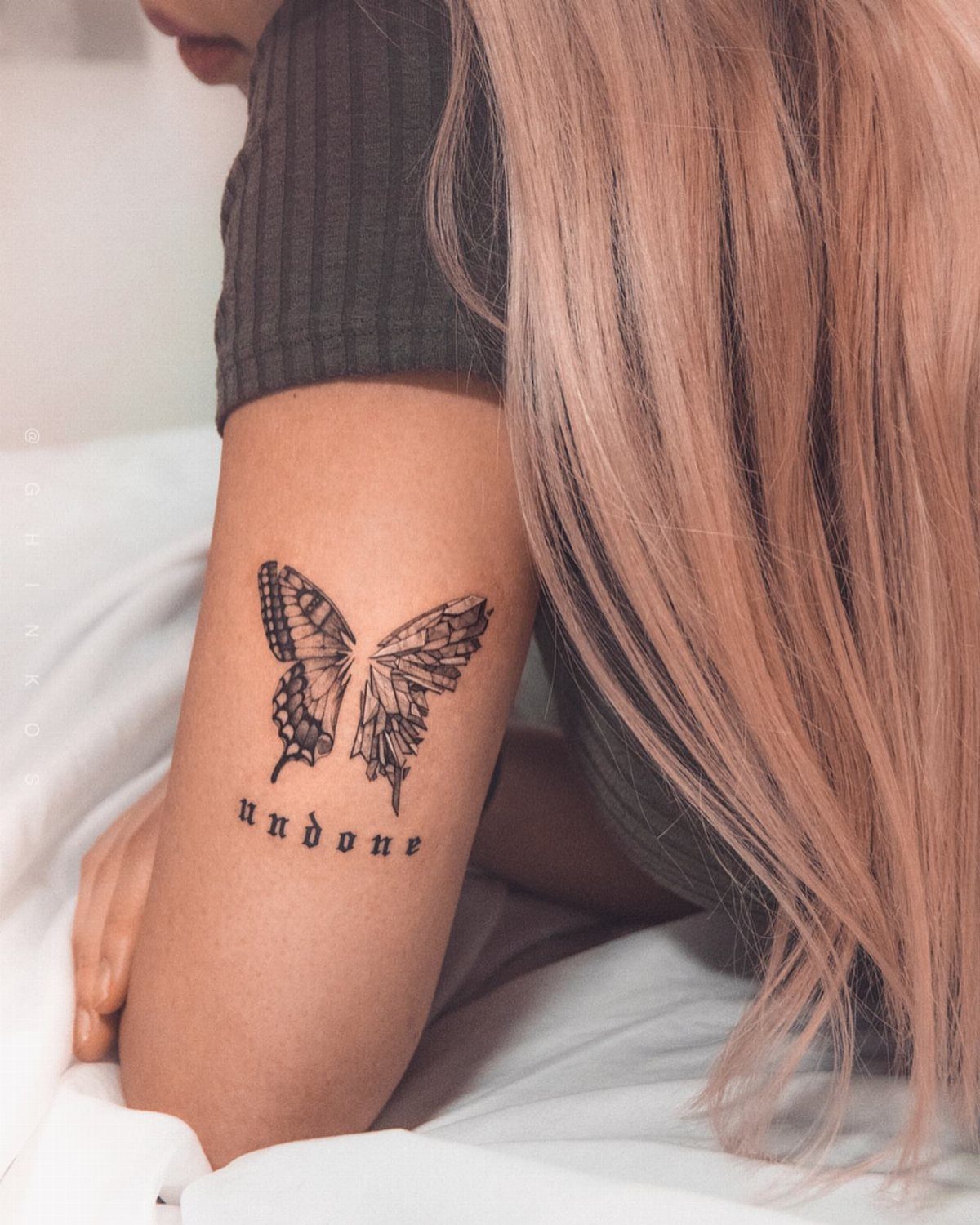Broken butterfly tattoo on an arm with the word undone written below it