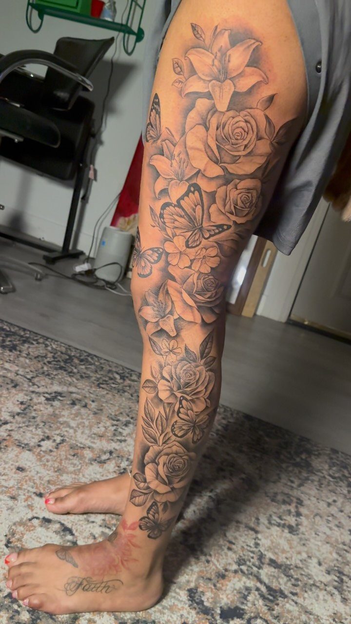 Leg tattoo with roses and butterflies extending from the thigh to the ankle.