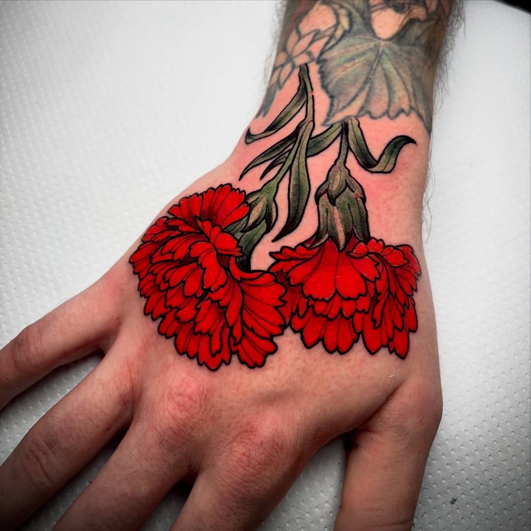 Red carnation flower tattoo on the back of a person's hand