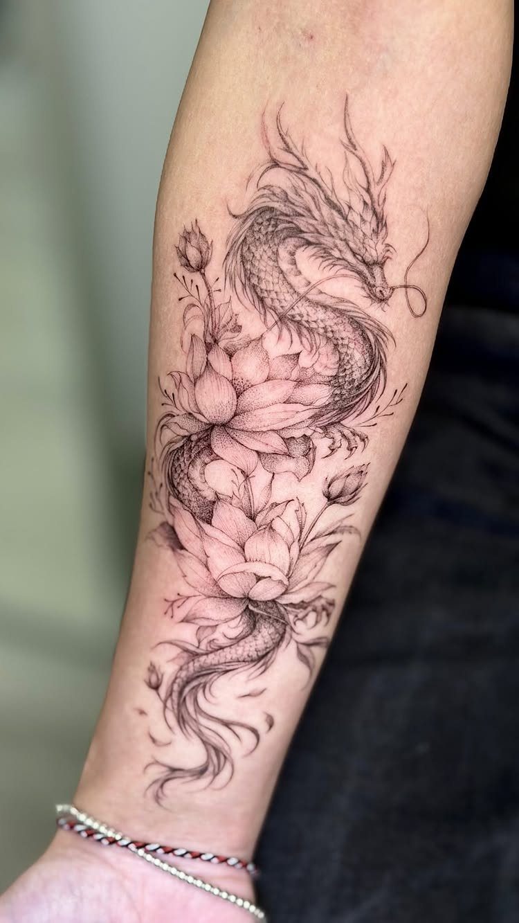 Fine-line dragon tattoo entwined with lotus flowers on a person's forearm