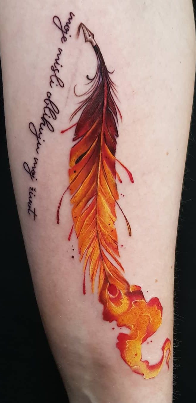 Phoenix feather tattoo with red and orange flames and cursive text on arm