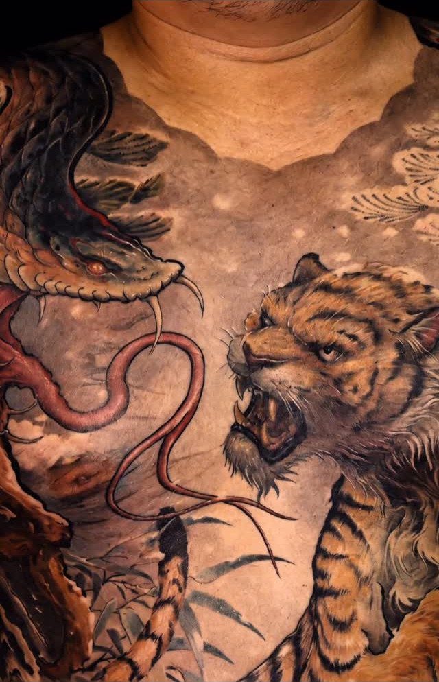 Japanese tiger and snake tattoo on a person's chest in traditional style