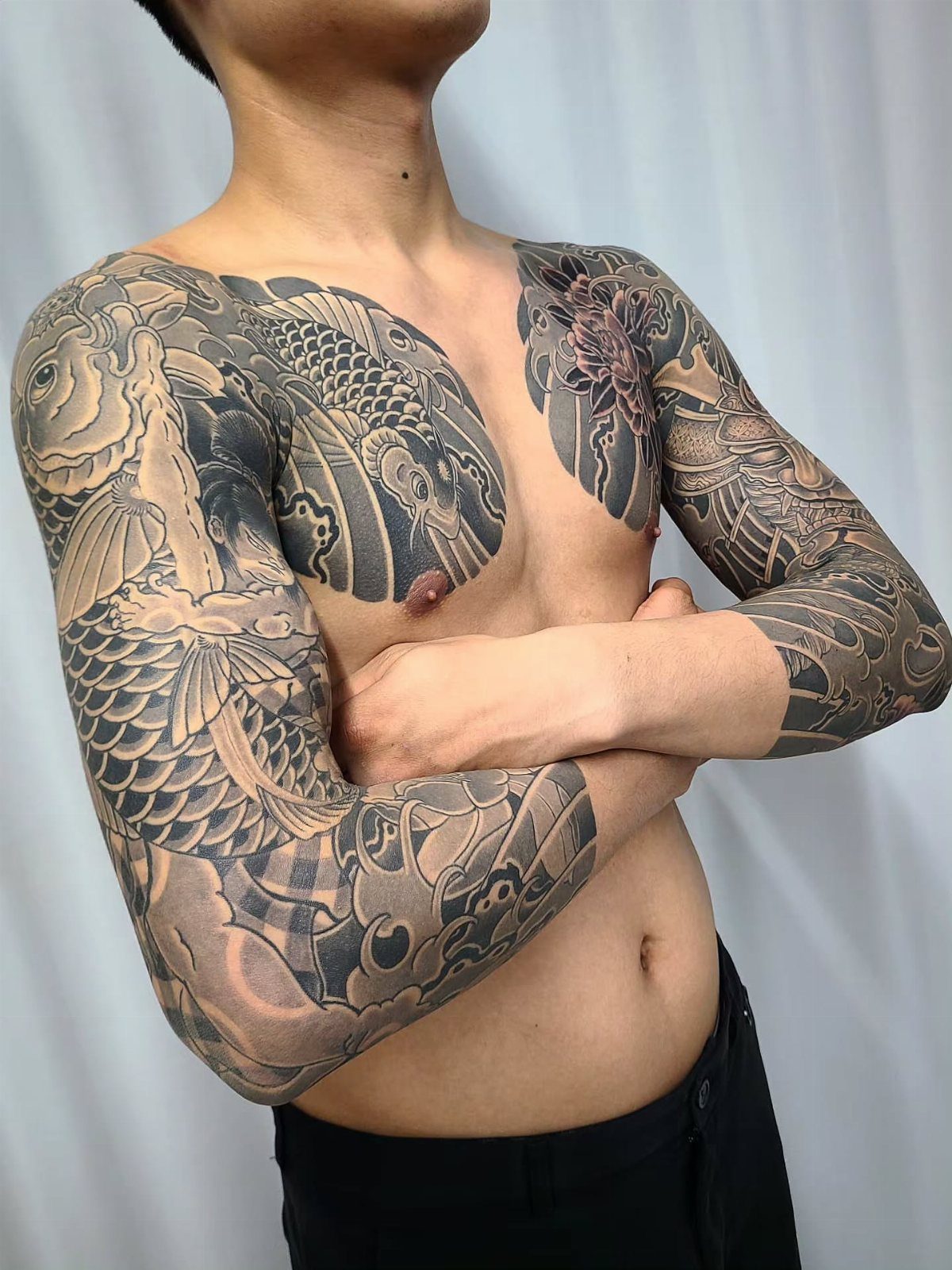 Koi fish tattoos covering the chest and arms of a man.