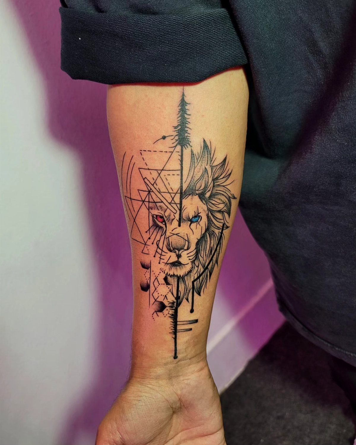Lion forearm tattoo with one side realistic and the other side geometric lines