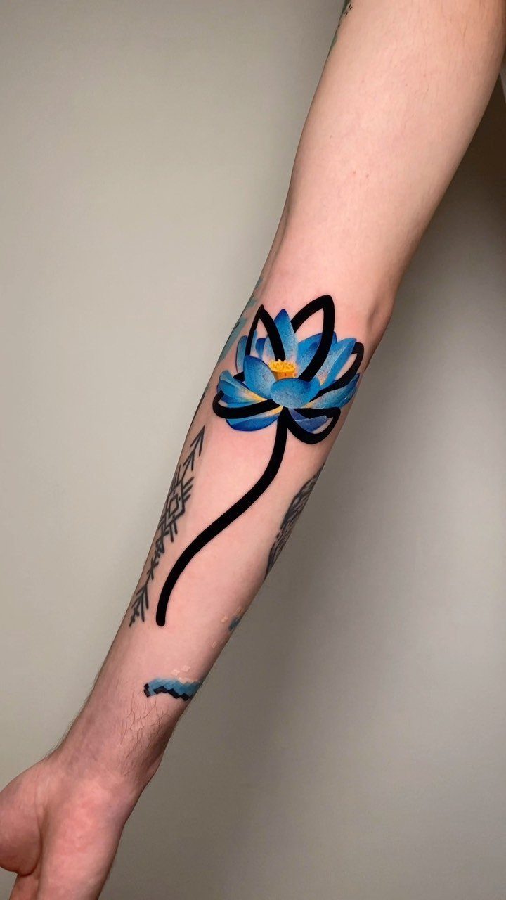 Blue lotus flower tattoo with black outlines on a person's forearm.