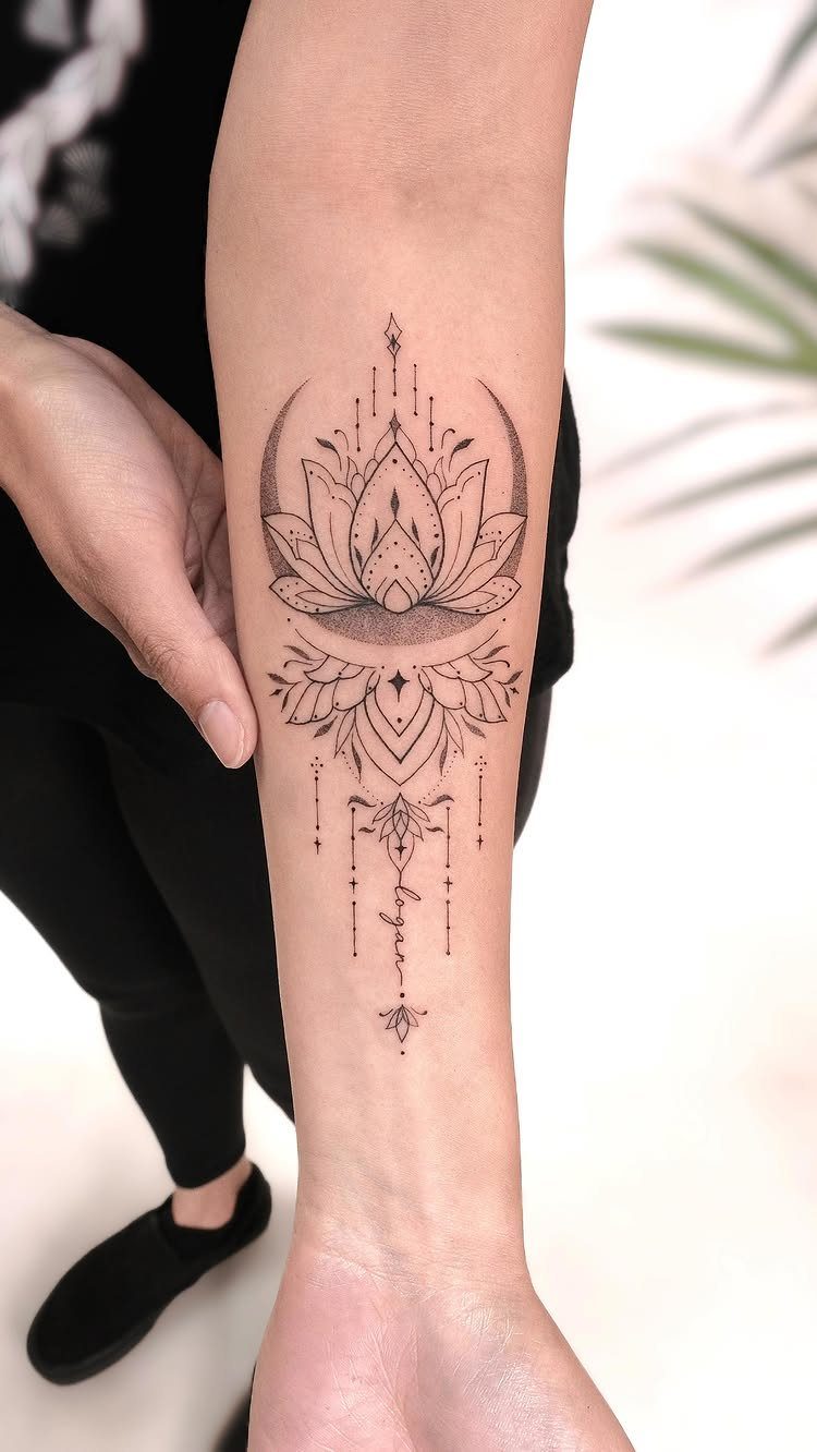 Lotus flower and crescent moon tattoo with geometric details on a forearm