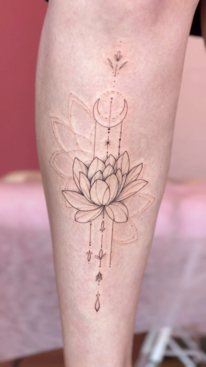 Lotus flower and crescent moon tattoo with mandala elements on a forearm