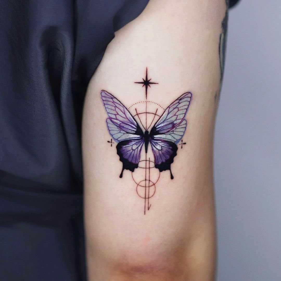 Purple butterfly tattoo on an arm with red geometric lines and a star.