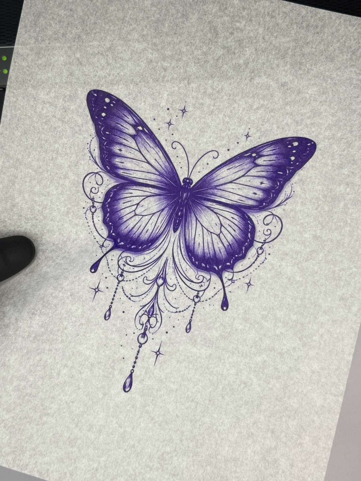 Purple butterfly drawing with stars and decorative swirls on white paper