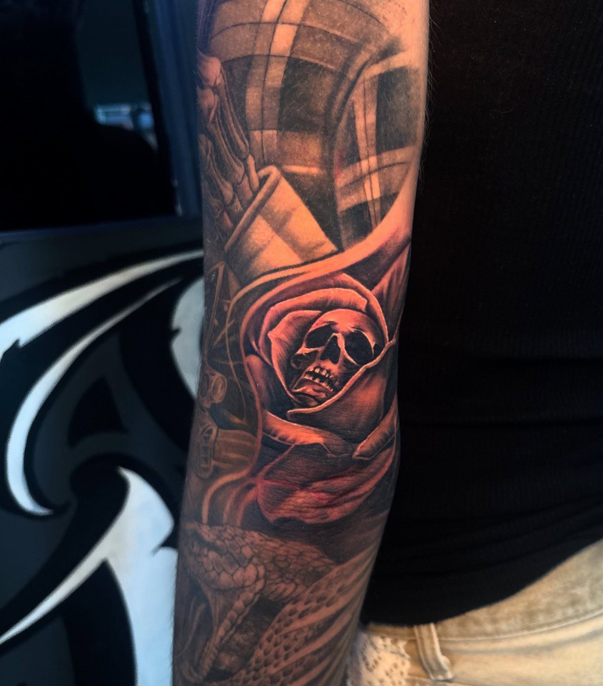 Red rose tattoo with a skull inside the petals on a person's arm