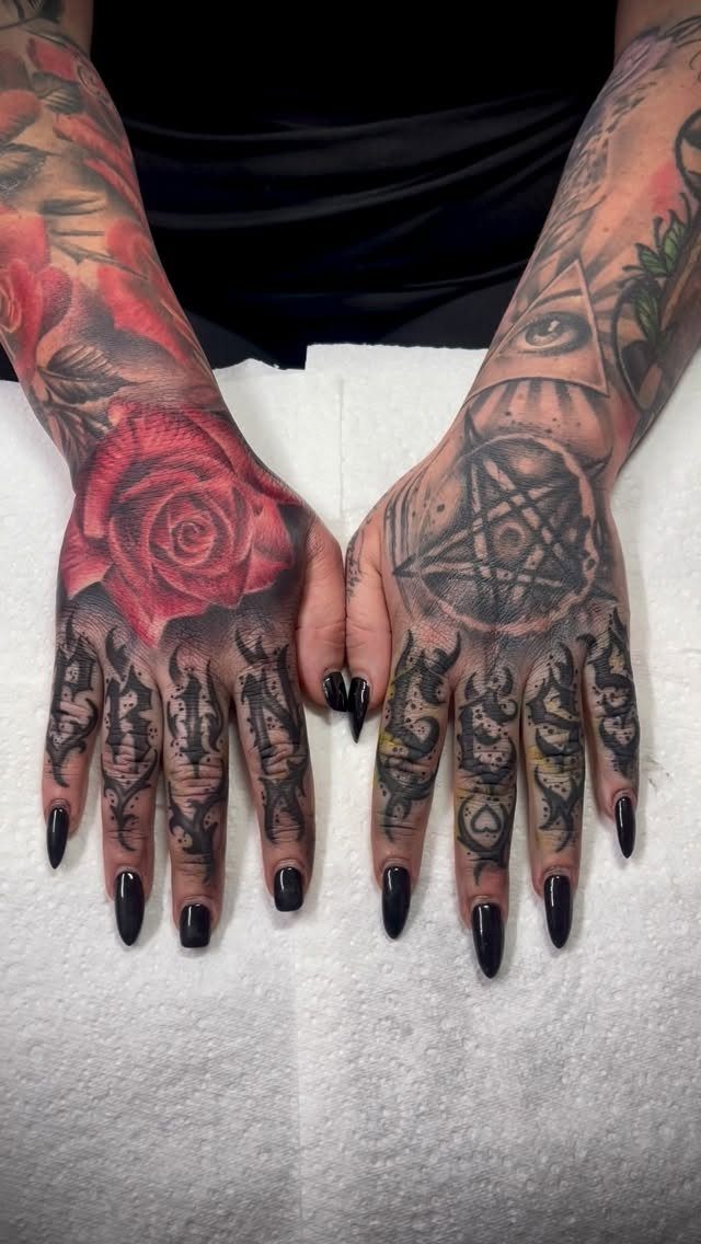 Tattooed hands featuring a large red rose and a pentagram on white background