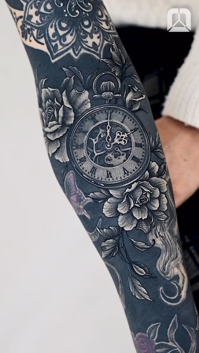 Pocket watch and roses tattoo in black and grey ink on an arm