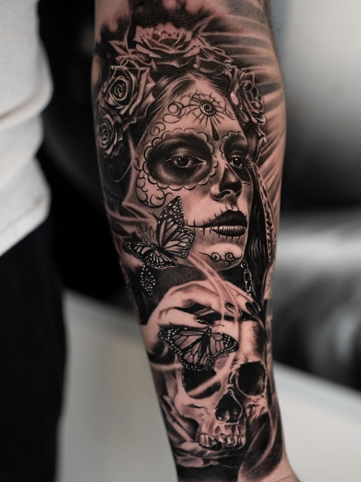 Tattoo of a sugar skull woman and skull with roses and butterflies