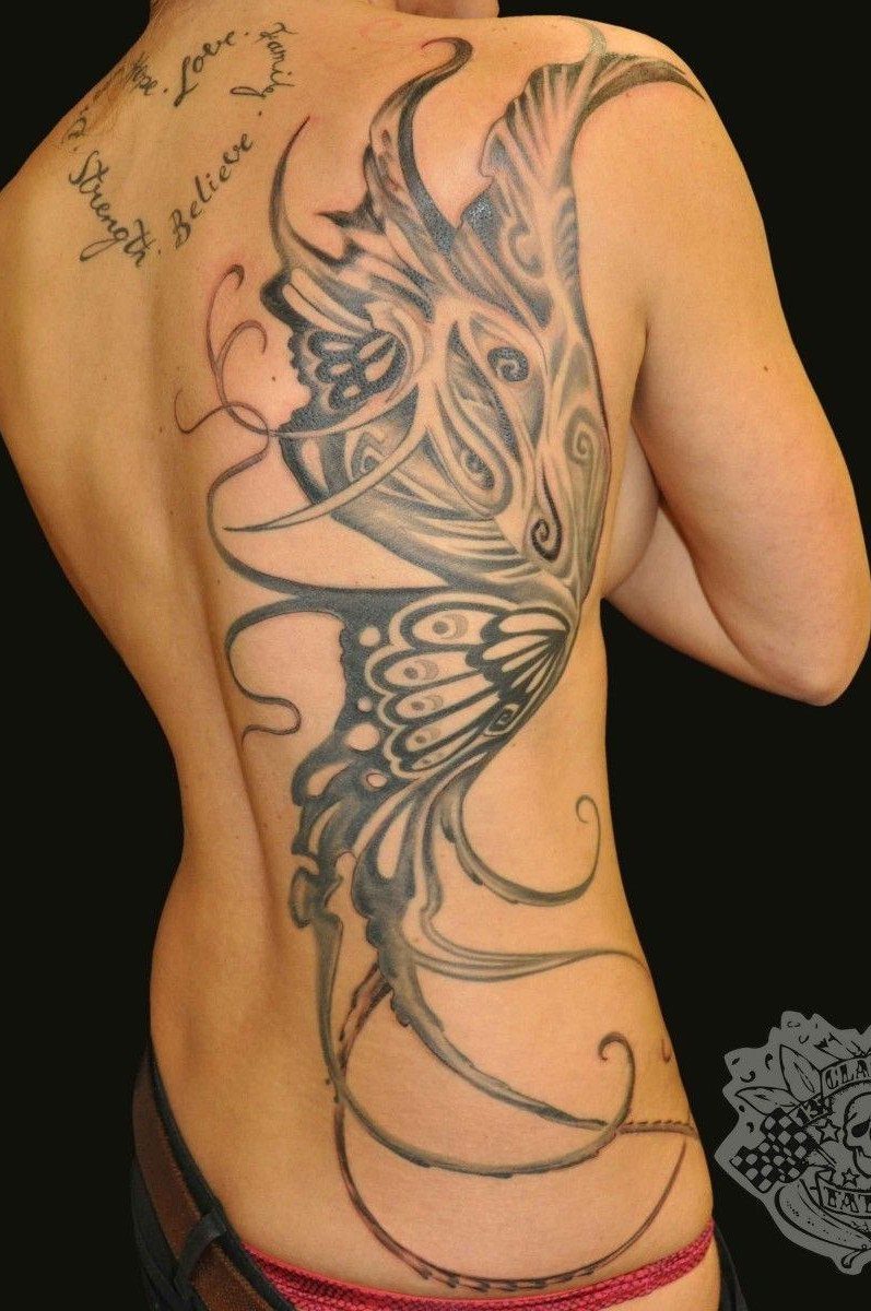Stylized butterfly tattoo with flowing abstract lines covering a person's entire back.