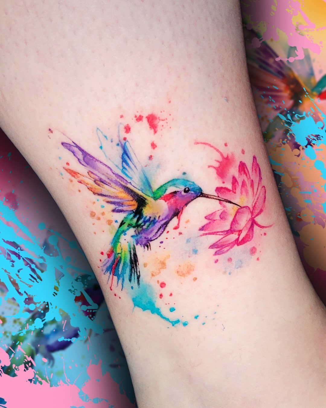 Watercolor tattoo of a colorful hummingbird and pink lotus flower on a forearm
