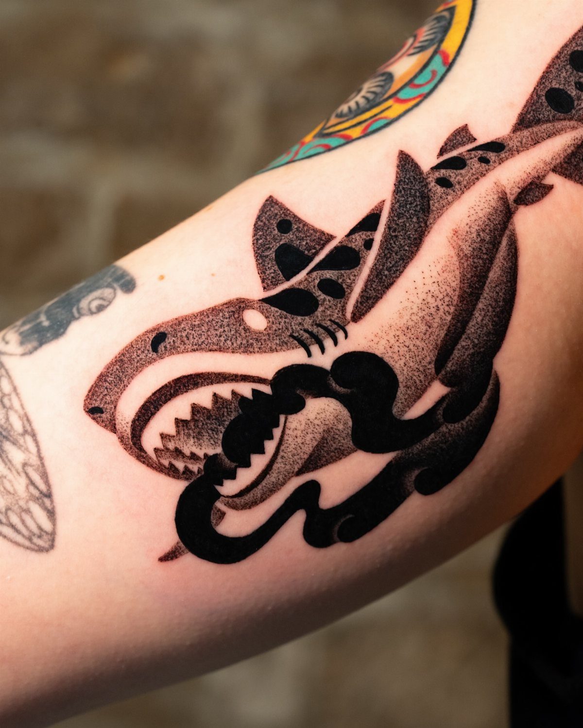 Stylized black ink tiger shark tattoo with dotwork on a person's arm.