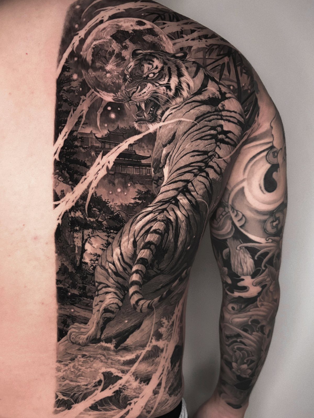 Full-bodied tiger tattoo in motion on a man's side and arm.