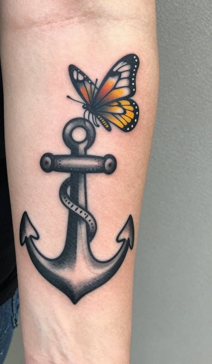 Traditional tattoo of a colorful butterfly perched on a grey anchor on a forearm