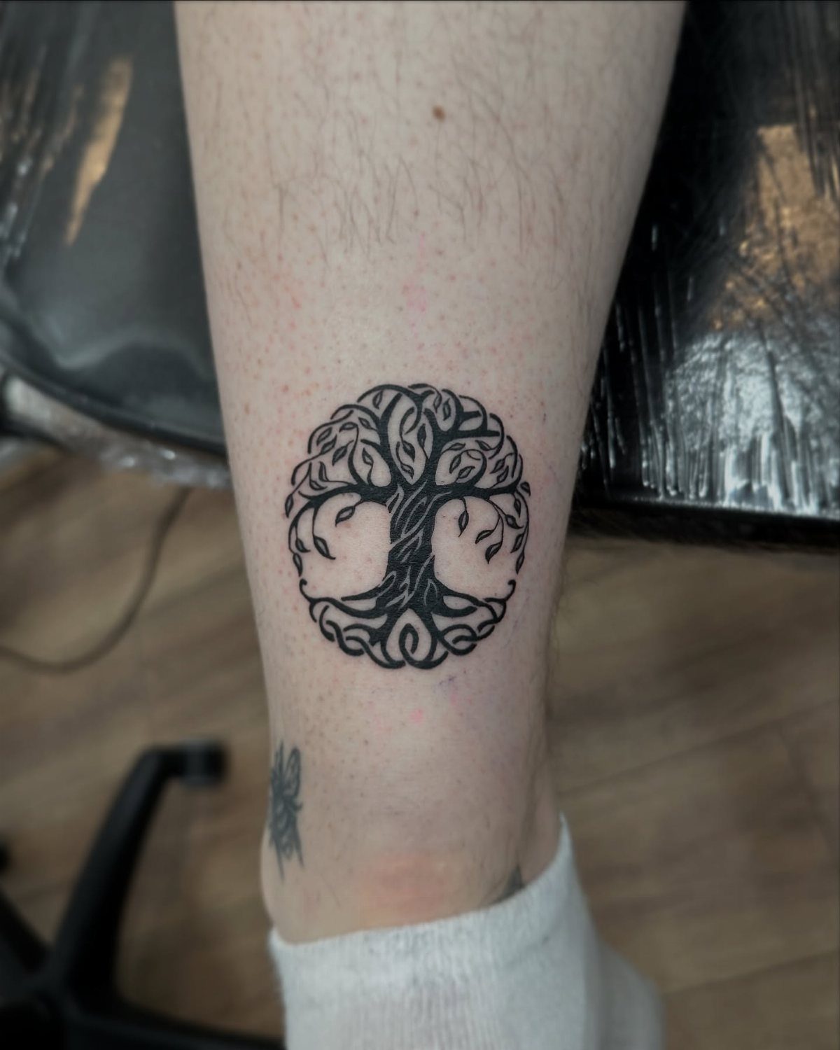 Celtic tree of life tattoo with interlaced knots on a person's ankle