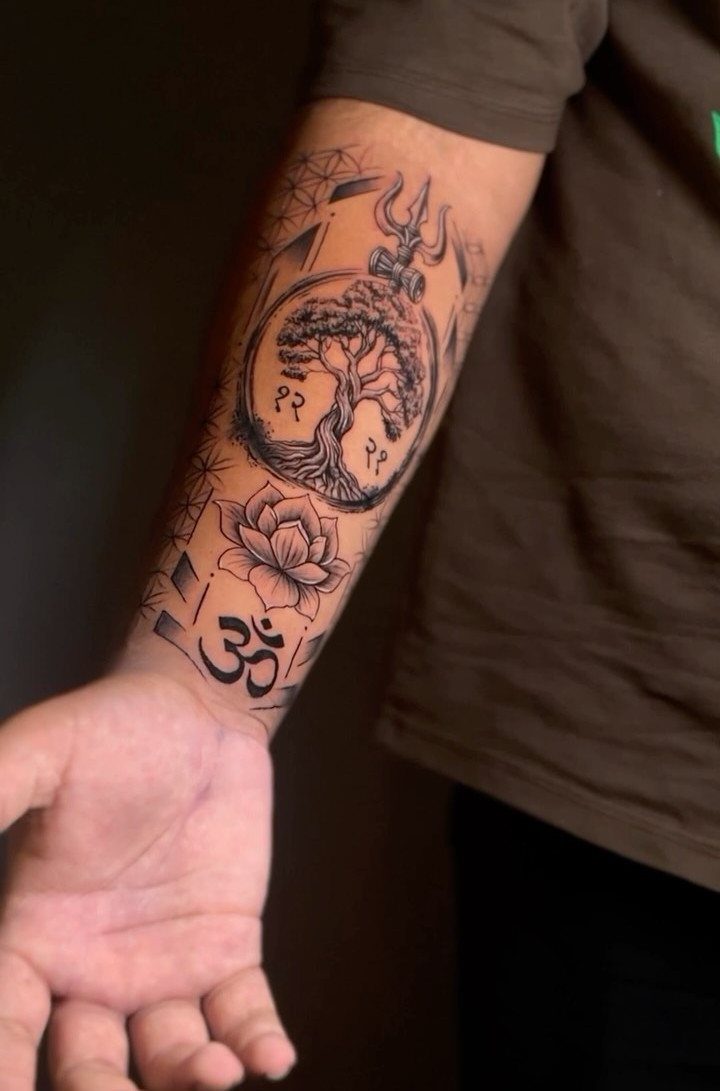 Tree of life tattoo on a forearm with lotus and Om symbols.
