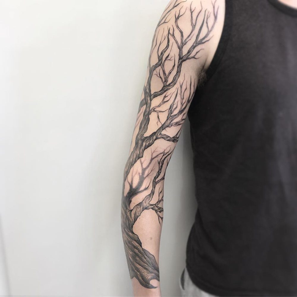 Tree tattoo sleeve with intricate black branches covering a person's entire arm.